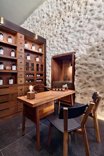 a dining room with a wooden table and chairs at Hotel Xcaret Arte - All Parks All Fun Inclusive - Adults Only in Playa del Carmen