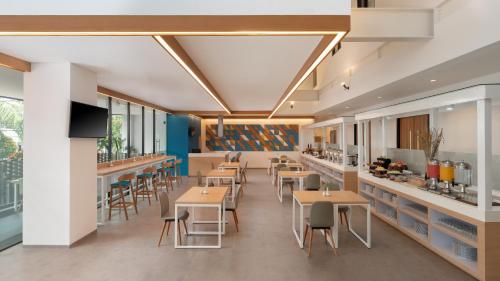 a restaurant with tables and chairs and a bar at Hotel 88 Blok M Jakarta By WH in Jakarta