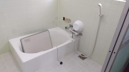a bathroom with a shower with a white tub at 一棟貸切糸島リトリートハウスヨガ凪海近駅近 in Itoshima