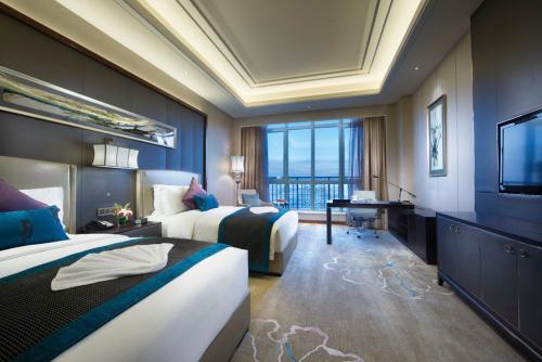 a hotel room with two beds and a flat screen tv at Crowne Plaza Tianjin Jinnan, an IHG Hotel in Tianjin