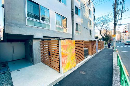 a building with a wooden fence next to a street at japan house nishishinjuku in Tokyo