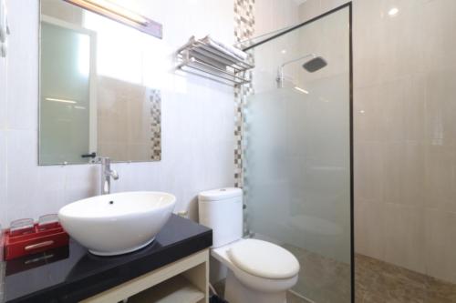 a bathroom with a sink and a toilet and a mirror at Pejaten Valley Residence in Jakarta