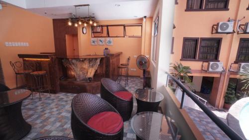 a room with a bar with chairs and a fireplace at 1775 Adriatico Suites in Manila