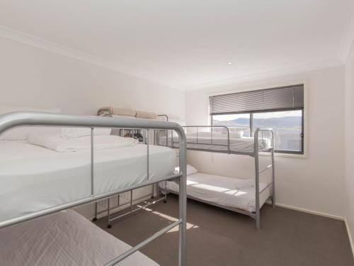 two bunk beds in a white room with a window at Northstar 10 17 Kirwan Close in Jindabyne