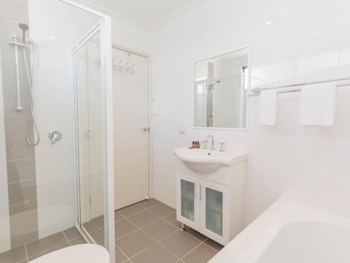 a white bathroom with a sink and a shower at Northstar 10 17 Kirwan Close in Jindabyne