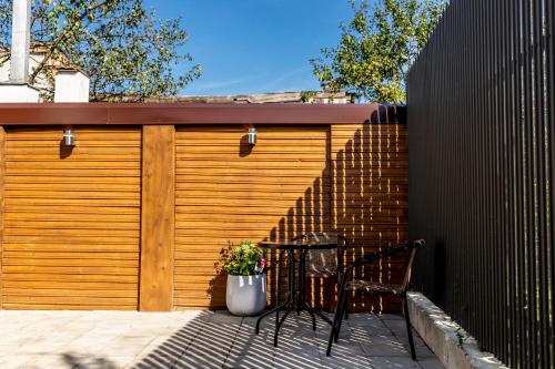 una porta in legno del garage con tavolo e sedie su un patio di Corvin Guesthouse a Hunedoara