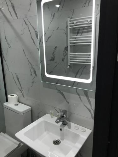 a white bathroom with a sink and a mirror at D and D hotel in Tbilisi City