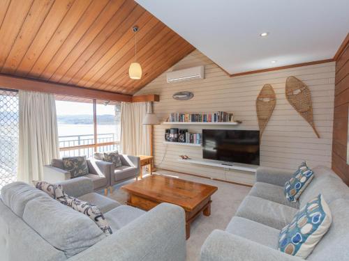 a living room with two couches and a television at Platypus 19 McLure Circuit in Jindabyne