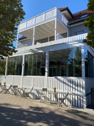 a building with tables and chairs in front of it at Weyotel in Weyhe