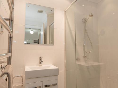 a white bathroom with a sink and a shower at Dauphine 1 23 Townsend Street in Jindabyne