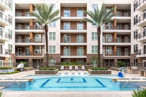 an apartment building with a swimming pool and palm trees at Downtown Houston Condo w Pool and Free Parking 6 in Houston