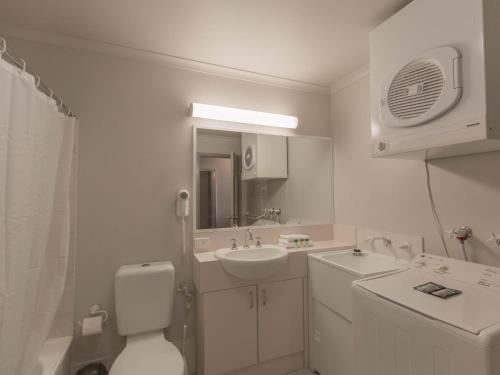 Un baño blanco con lavabo e inodoro. en Horizons 315/10 Kosciuszko Road, en Jindabyne