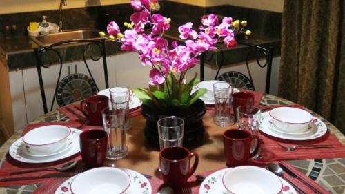 a table with red and white plates and a vase of flowers at 1775 Adriatico Suites in Manila