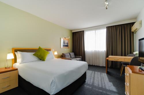 a hotel room with a large bed and a television at Mercure Albury in Albury