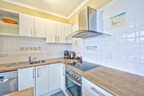 a kitchen with white cabinets and a sink at Snow Ski Apartments 26 in Falls Creek