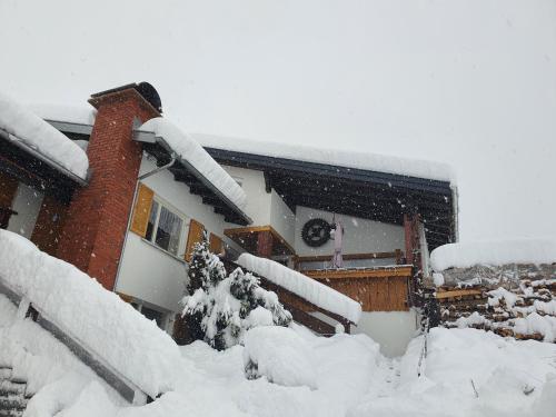 a house with snow on the roof of it at DreamlandRanch Vorarlberg in Schlins