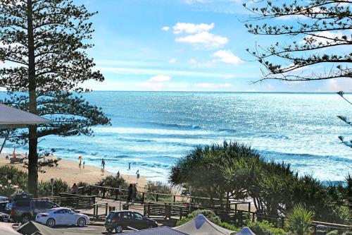 a view of a beach with cars parked on it at Coolum Beachside Studio in Coolum Beach