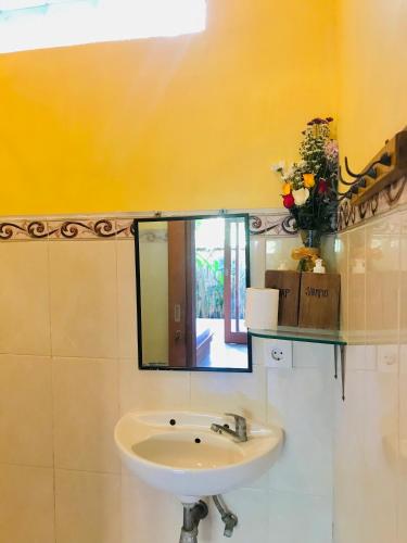 a bathroom with a sink and a mirror at Putu Homestay in Canggu