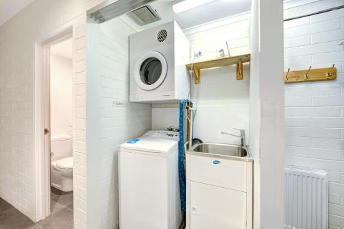 a small bathroom with a sink and a washing machine at Snow Ski Apartments 36 in Falls Creek
