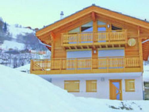 Lavish Holiday Home in H r mence with Balcony في Hérémence: مبنى مع شرفة فوق منحدر مغطى بالثلج