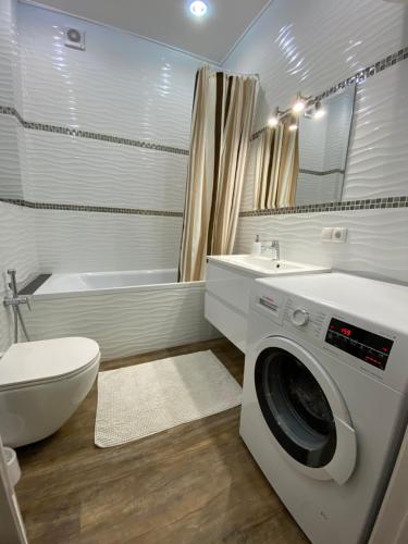 a bathroom with a washing machine and a toilet at Апартаменти ЖК"Театральний" in Rivne