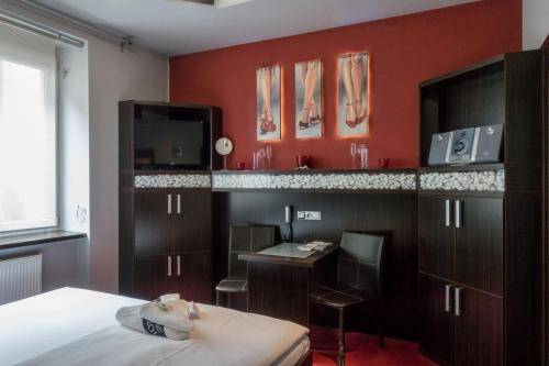 a room with a bed and a desk and a tv at Hotel Plzeň in Plzeň