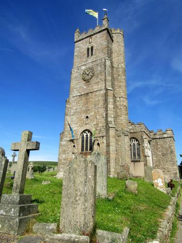 an old church with a clock tower in a cemetery at The Old Post House in Moretonhampstead