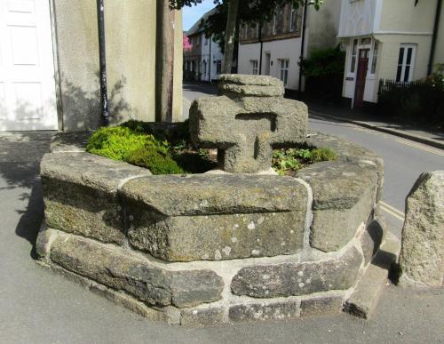 a stone wall with a cross on the side of a street at The Old Post House in Moretonhampstead