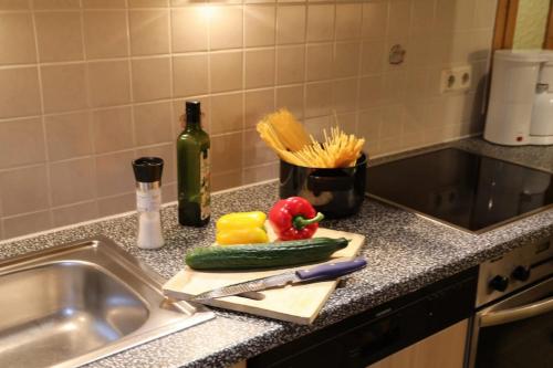 eine Küchentheke mit einem Messer und Gemüse auf einem Schneidebrett in der Unterkunft Ferienhof Seeber in Weikersheim