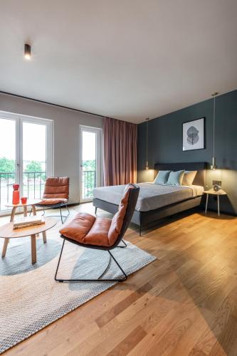 a bedroom with a bed and a chair and a table at ipartment Braunschweig in Braunschweig