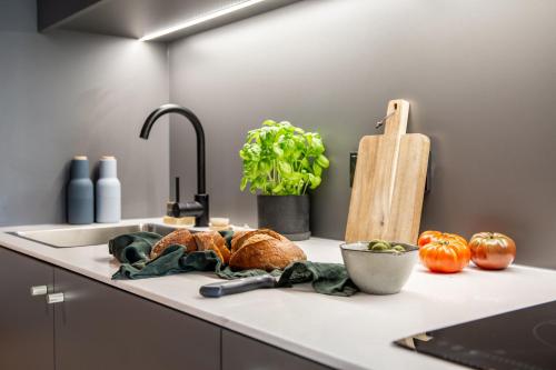 a kitchen counter with a sink with bread and vegetables at ipartment Braunschweig in Braunschweig