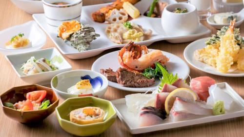 a table with plates of different types of food at Karatsu Seaside Hotel in Karatsu