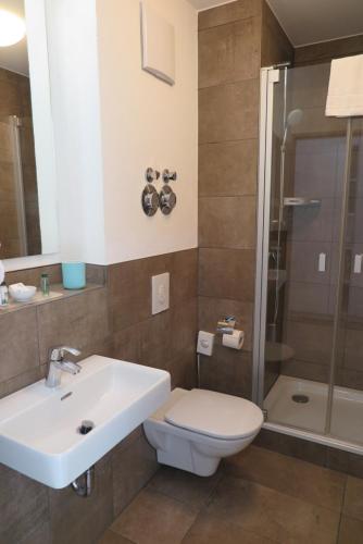 a bathroom with a sink and a toilet and a shower at Spreepolis Boardinghaus in Berlin