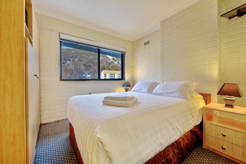 a bedroom with a large bed with a window at Snow Ski Apartments 14 in Falls Creek