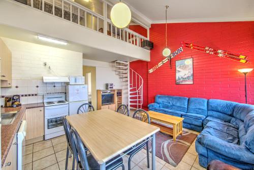 a living room with a blue couch and a table at Snow Ski Apartments 14 in Falls Creek