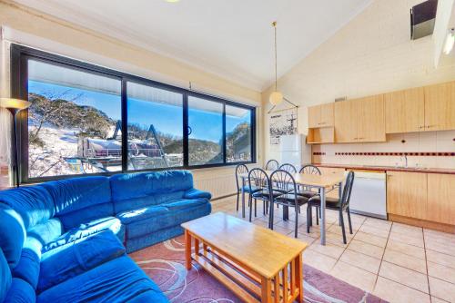 a living room with a blue couch and a table at Snow Ski Apartments 14 in Falls Creek