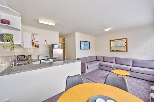a living room with a couch and a kitchen at Snow Ski Apartments 12 in Falls Creek
