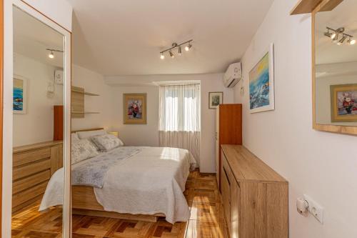 sypialnia z łóżkiem i lustrem w obiekcie Apartments Lapis w mieście Jadranovo