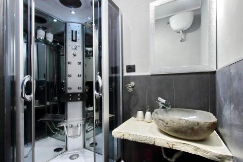 a bathroom with a stone sink and a shower at Suite Paradise Rome Guest Rooms in Rome