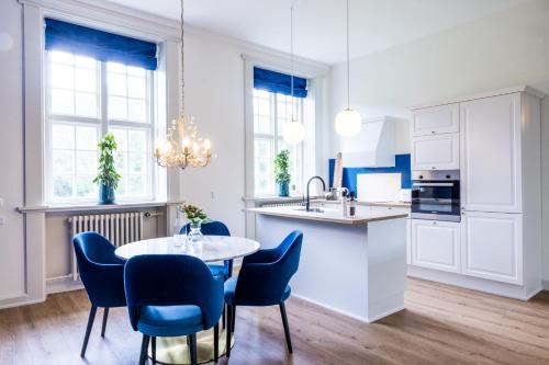 uma cozinha com cadeiras azuis e uma mesa numa cozinha em 'Gem Suites Luxury Holiday Apartments em Augustenborg