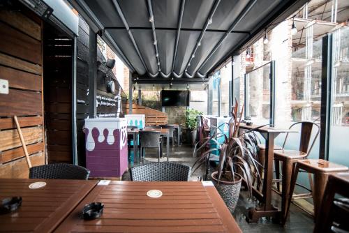 a restaurant with wooden tables and chairs and windows at Lower Turks Head in Manchester