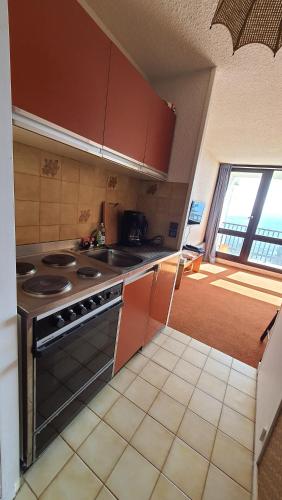 a kitchen with a stove and a counter top at Studio 05 Saint Honoré 1500, Vue montagne et lac, 2 personnes, Série Anthracite Netflix in Saint-Honoré