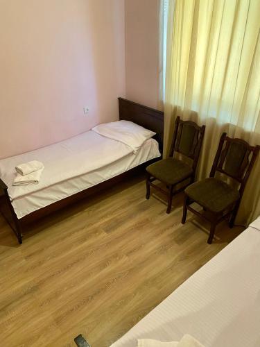a small bedroom with two chairs and a bed at Noravank B&B in Chʼiva