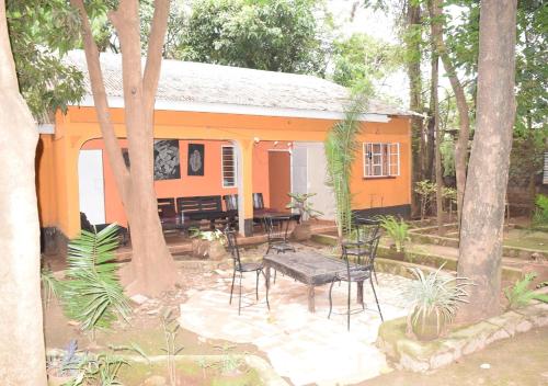 a house with chairs and a table in front of it at Mamba Village Kisumu in Kisumu