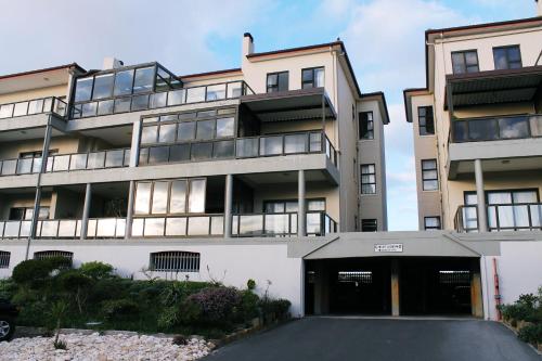 an apartment building with a parking lot in front of it at Waves Edge CP3 in Cape Town