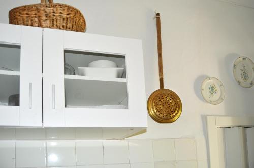 a kitchen with white cabinets and baskets on the wall at La Vieja Parra in La Puerta de Segura