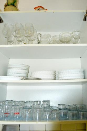 a shelf filled with glasses and plates and dishes at La Vieja Parra in La Puerta de Segura