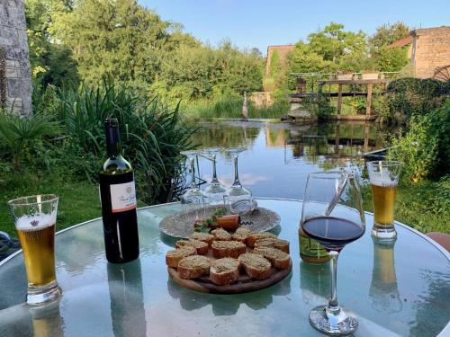 - une table avec des verres de vin et une assiette de nourriture dans l'établissement Rue des Douves, à Verteuil-sur-Charente