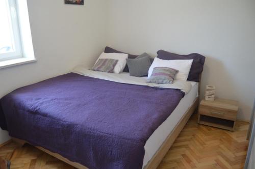 Un dormitorio con una cama con sábanas y almohadas púrpuras. en Lipa Mare, en Solin