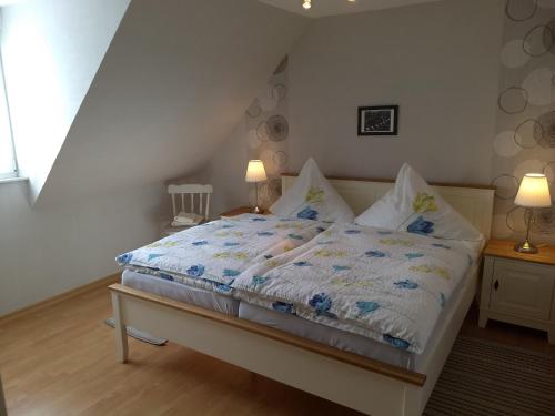 a bedroom with a bed with a blue and white comforter at Ferienwohnungen Peters in Neuharlingersiel